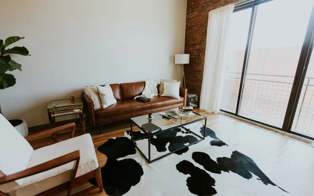 A measured living room with a sofa, rug, and clear walking space